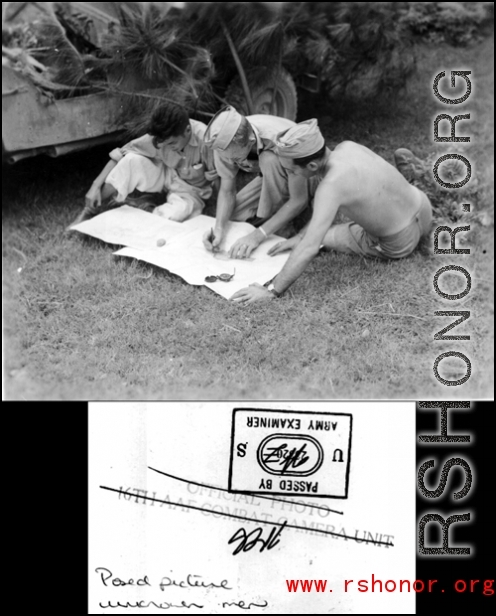 GIs looking at map next to their camouflaged jeep. In China during WWII.