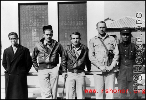 American air men who survived an air incident, with some of the Chinese men who took care of them on the ground. During WWII, in China.  The plaque on the back is commemorating the construction of a local fortress ("青年堡垒").