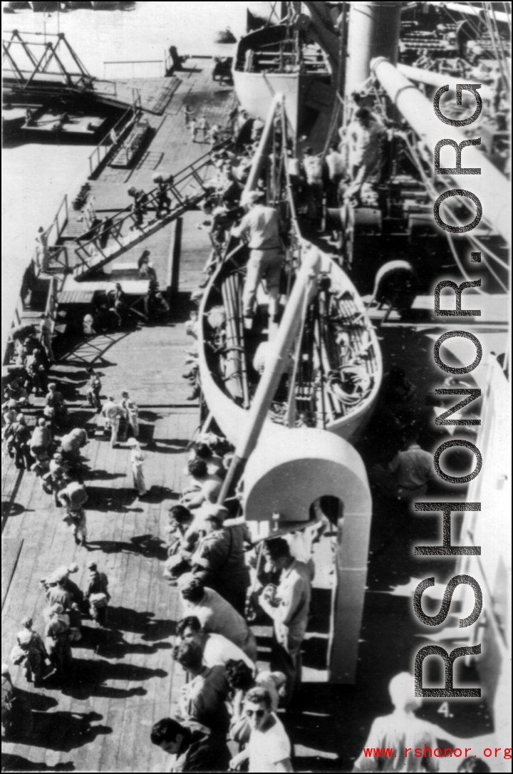 GIs board ship on the way back to the US after the war. The ship is probably the SS Marine Raven.