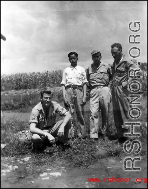 Left to right: Unknown, houseboy, Robert Zolbe, and unknown pose in front of corn field in the CBI. During WWII.