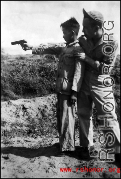 Robert Zolbe teaches the barracks houseboy how to shoot a pistol. In China during WWII.