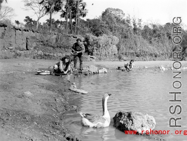 Local people in a village near Yangkai, Yunnan province, China, was items in a pond. During WWII.