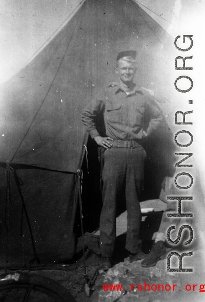 Rex B. Gouger, member of the 76th Fighter Squadron, 23rd Fighter Group, poses in front of a tent in the CBI during WWII.