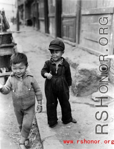 Local kids in China: Boy and girl on the side of the street in SW China during WWII.