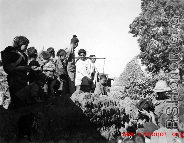 Local people in Yunnan province, China, are curious about the visit of a American photographer, during WWII.
