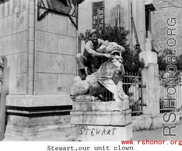 "Stewart, our unit clown" standing on a stone lion near a gate in Yunnan province, China, during WWII.