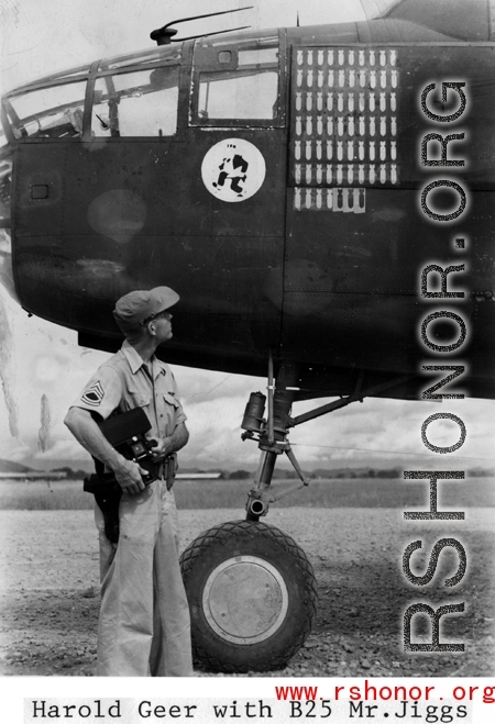 Combat Photographer Harold "Hal" Geer examines masking on bomb icons on a B-25  of the 11th Bomb Squadron (indicated by the "Mr. Jiggs" insignia) readying for painting to indicate three more bombing missions. In southwest China during WWII, as photographed by Selig Seidler, 16th Combat Camera Unit, in the CBI during WWII.