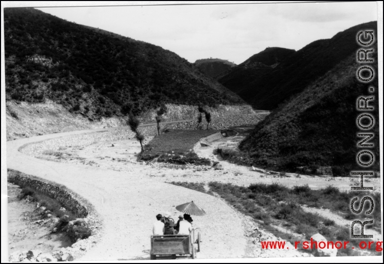 A simple vehicle passes along a newly cut road in SW China during WWII.