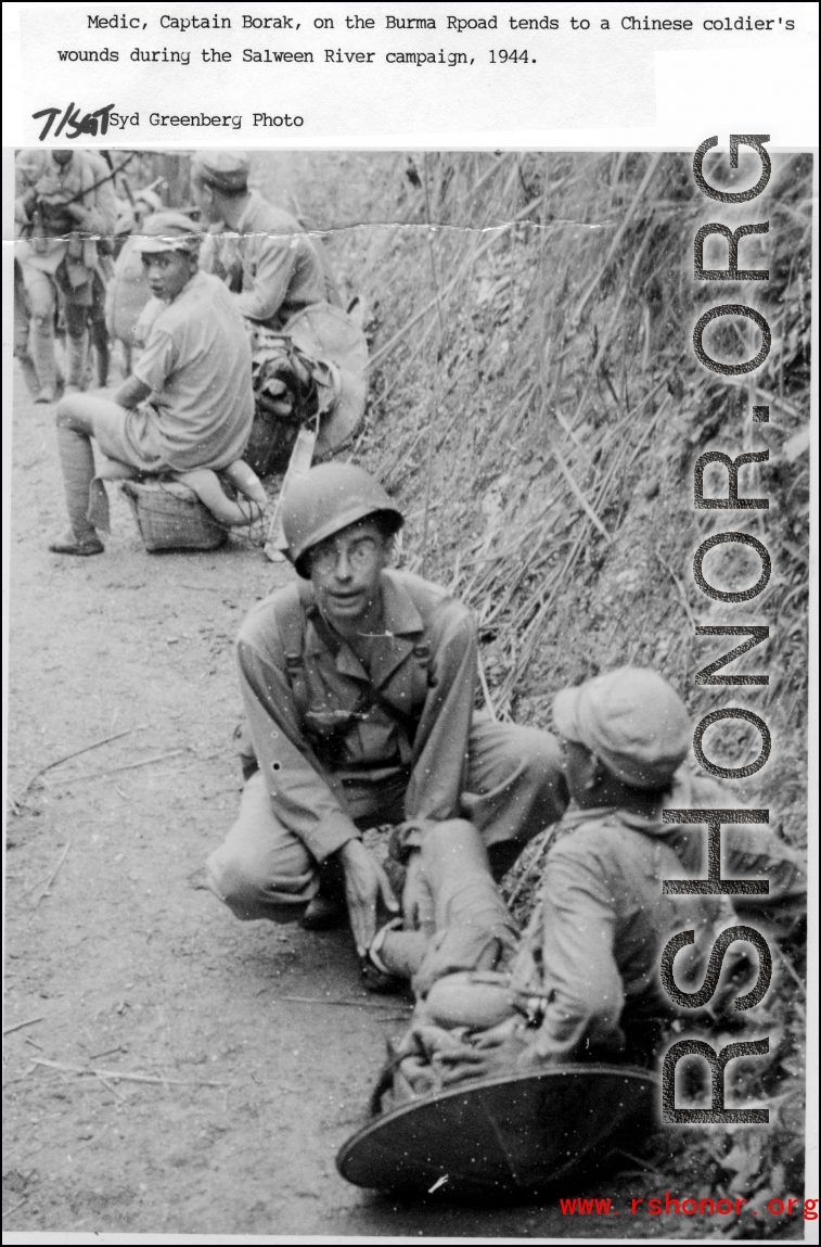 Medic, Captain Borak, on the Burma Road, tends to a Chinese soldier's wounds during the Salween River Campaign, 1944.  Photo by T/Sgt. Syd Greenberg.