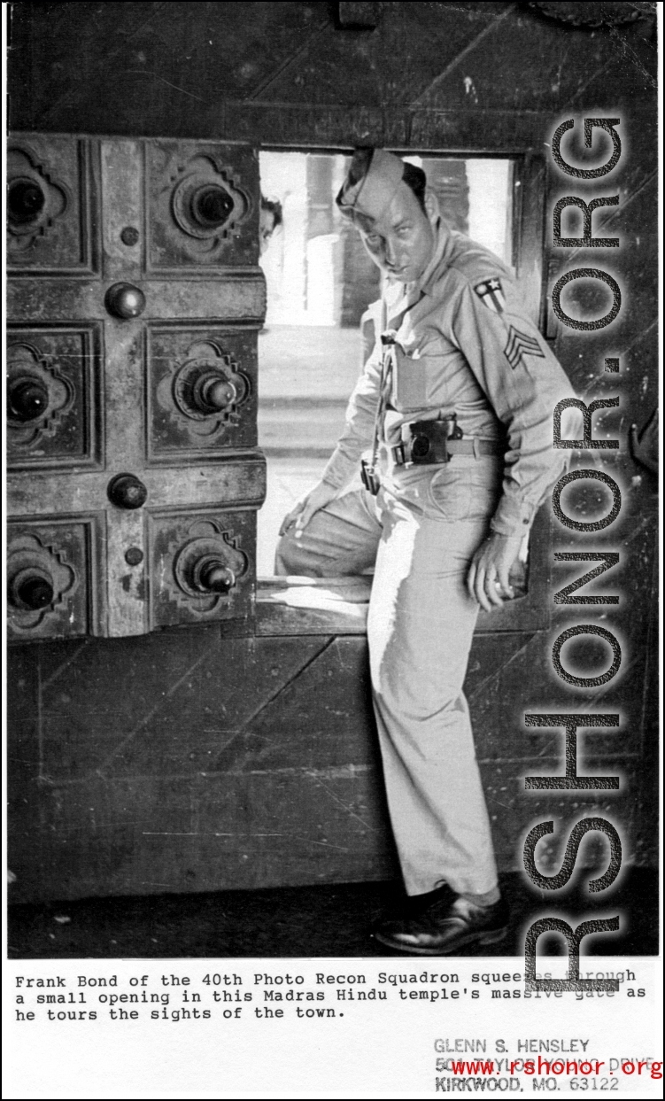 Frank Bond of the 40th Photographic Reconnaissance Squadron squeezes through a small door in a massive gate of a Hindu temple in Madras, India, during WWII.  Photo from Glenn S. Hensley.