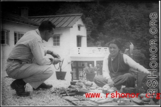 A GI talks to a local woman in the Himalayas, probably negotiating over prices for wares.    From "P. Noel" showing local people and scenes around Mussorie, India.    In the CBI during WWII. 