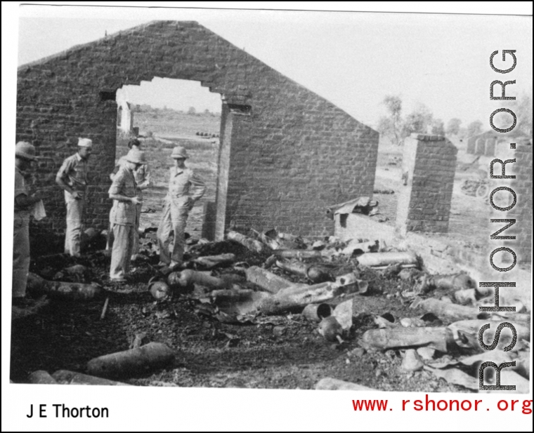 GIs look over destroyed bomb stores in destroyed store building. During WWII.  Photo from J. E. Thorton.