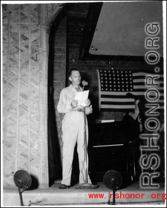 A GI reads from a script during a variety show, while the band Jive-o-Lieps prepares to play music in the CBI during WWII. 54th Air Service Group.