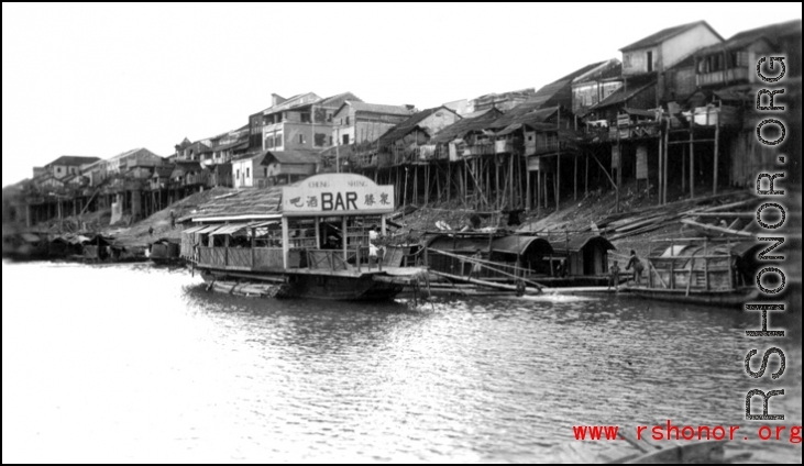 The bar barge and stilted houses at Liuzhou. Looking toward the other side of Liuzhou from the boat bridge, Sept. 1944.   From the collection of Frank Bates.