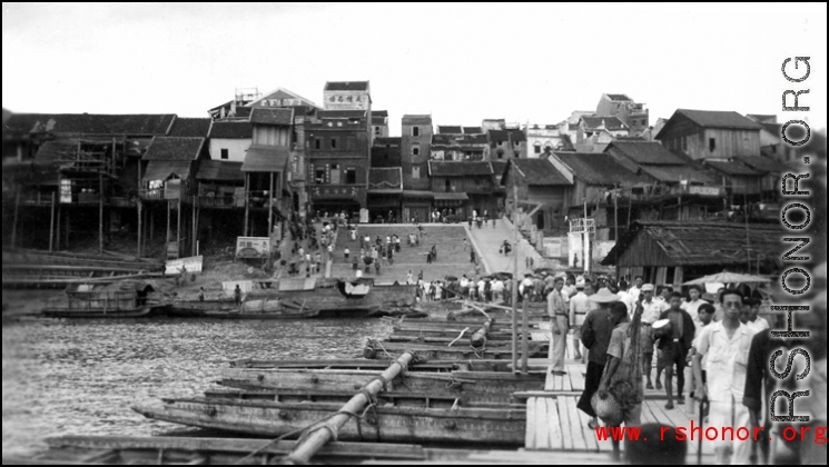 Looking toward the other side of Liuzhou on the boat bridge. Johnnie Burns is a couple of boats ahead, looking back. The barge is off to the left where the kids are swimming.  From the collection of Frank Bates.