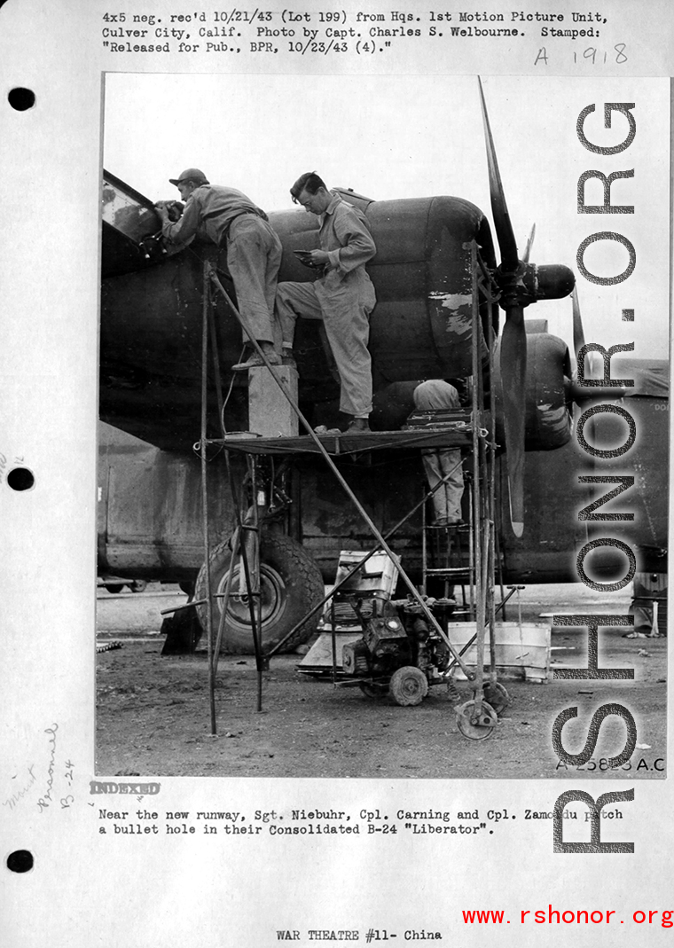 Near the new runway, Sgt. Neibuhr, Cpl. Carning, and Cpl. Zamoidu repair of a bullet hole in a B-24 in the CBI. Photo by Capt. Charles S. Welbourne. 1943.