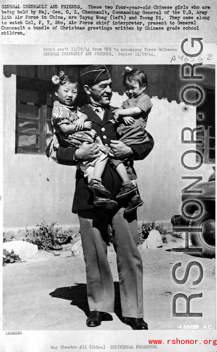 Chennault holds Tayng Wong and Toong Di, who had come with Col P. Y. Shu, interpreter, to present Chennault Christmas greetings written by grade school children. During WWII.