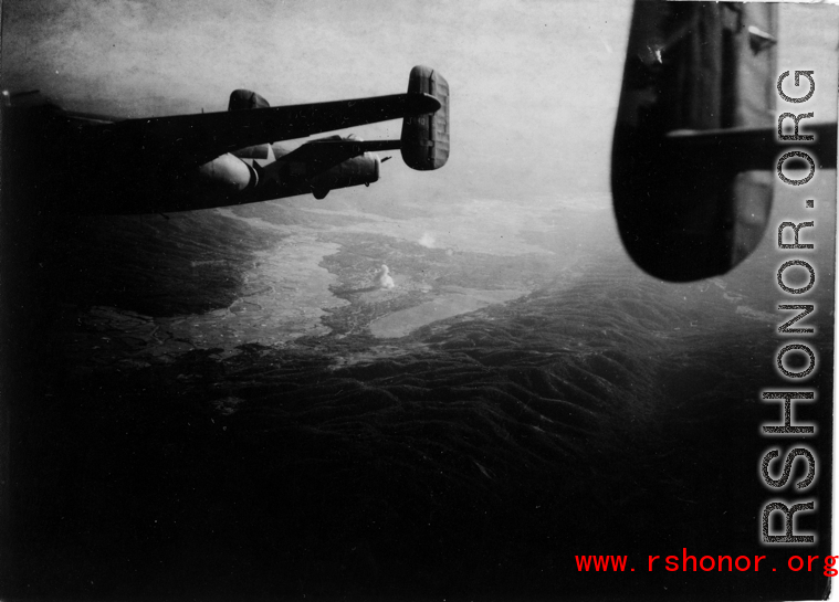 Smoke rises on the ground behind B-25 #440 after an attack by American B-25s, likely in SW China, fairly close to Tengchong.  An image from the collection of Eugene T. Wozniak. 