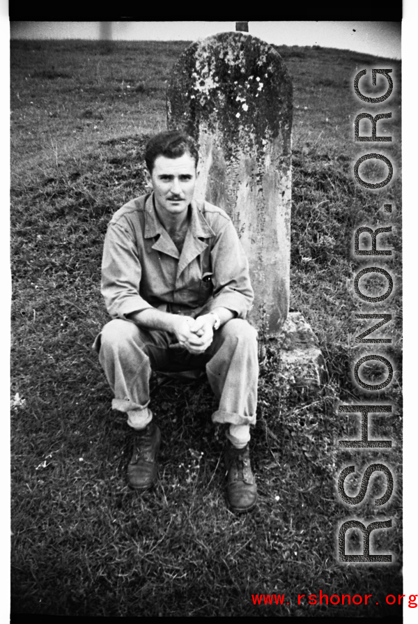 An image showing the GI photographer and collector of these photos (name unknown) sitting in front of a tomb, in Yunnan province, China.