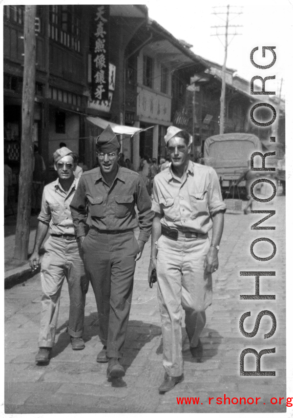 American GIs walking down the road in China during WWII, probably in Yunnan province (based on the architecture in the background). On the right is Frank G. Ehle.
