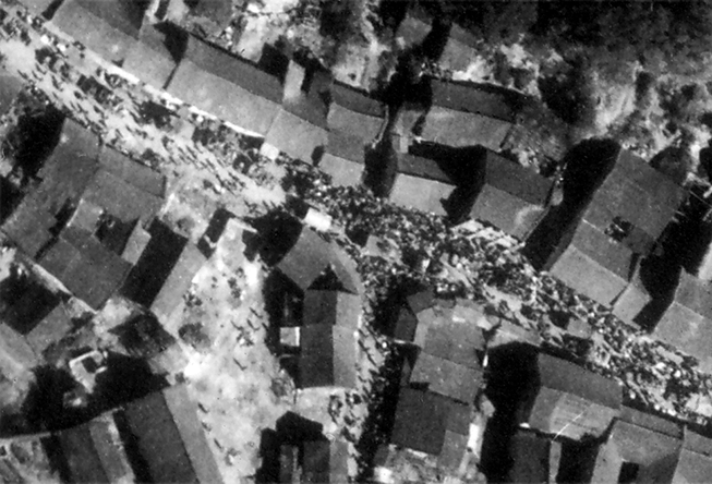 The town densely crowded with trucks, munitions, and artillery in a convoy, as well as dense crowds of Chinese civilians, seconds before the bombs hit.