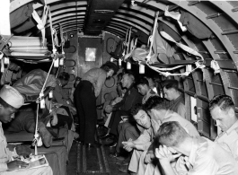 GIs and flight nurse (probably) on a transport plane. In the CBI during WWII.