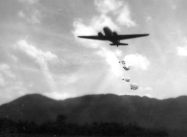 An American transport plane drops supplies by parachute somewhere in the CBI.