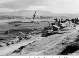 Control tower (arrow, center) and enlisted men's barrack (right center) of the 1339th AAFBU at Chengkung, Yunnan province, China. Four B-24s are scattered around the field.