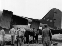 Unloading or loading supplies from C-47 transport plane in China during WWII.