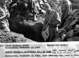 GIs dig slit trench in China during WWII, as local Chinese man looks on. James F. Porter, in center with pick, is digging because of a penalty for infraction of regulations.