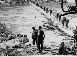 GIs cross Shweli River on bamboo pontoon bridge on January 2, 1945, in the CBI.