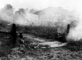 50th Division soldiers fires on Japanese position in burning hut at Hsipaw, Burma, during WWII.