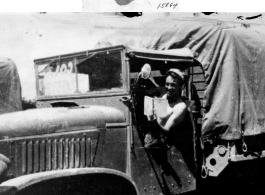 GI in driver seat of truck, with book in hand. In the CBI during WWII.  From Russell Walker.