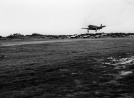 A P-51 fighter plane lands in front of a row of other P-51s in the CBI.