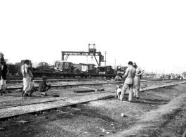 Local people in a train yard in India during WWII. Notice the first aid trucks on flat cars in the background.  From the collection of Eugene T. Wozniak.