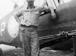 Elmer Bukey posing alongside a salvaged P-40 in the service area at Guilin. During WWII.