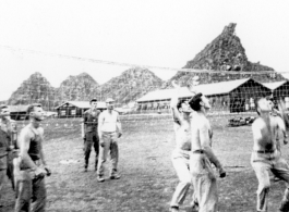 "This is some of the 396th guys playing volleyball in our hostel area at Kwelin, China. I cannot identify all of them but I do recognize "Doc" Savage...Joe Wiley...Caples, and our 1st sgt. Ed Gardner.  The unique mountain formation seen in the background of this photo was located alongside the runway at Kwelin, China and is still there to this day."