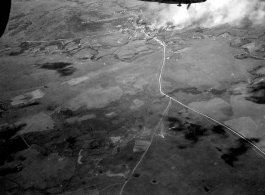 Smoke rises on the ground at a crossroads of the Burma Road after an attack by American B-25s in either SW China, Indochina, or the Burma area.  This might be fairly close to Tengchong in China.