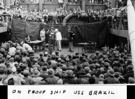 "On troop ship USS Brazil. Skit 'Calling Mr. Galloway.' Jules Kaufman & Johnny Klock of the 16th CCU in the middle of the group."  GIs on the way back home in the US after the war. The viewers include dozens of African-American GIs mixed in, before the stage.