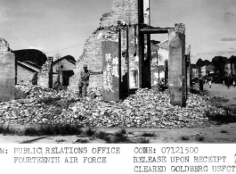 GI poses among the rubble. Bomb damage on a street corner in Liuchow (Liuzhou). The city and airfield both suffered heavily during the fighting that preceded the Japanese evacuation on June 30, 1945. A American serviceman stands in the foreground, next to a slogan that reads in Chinese, "Support Chairman Jiang", and the name of the building formerly, the "Lucky Cafe" shows on a concrete post on the right. 