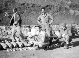 Lemmon, unkn0wn, Red Cummings, Peterson, Gibbs. Arming 100 lb. bombs, and goofing for the camera at the same time, in a revetment. During WWII.  Probably at Yangkai.