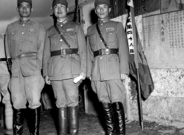 Young Nationalist officers stand before banners for different regiments of the 48th Army Division at rally.