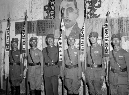 Banner bearers for different regiments of the 48th Army Division stand during rally, with 48th Army Division Zheng Tingji (郑庭笈), commander of the 48th Army Division holding the staff of the division banner. Left of him--the only person not holding a staff--is Chinese Lt. General Du Yuming, commander of Nationalist 5th Corps (第五集团军总司令兼昆明防守司令杜聿明).