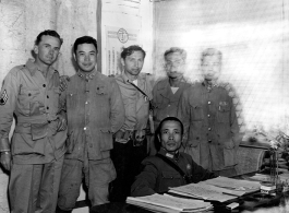  A very emaciated and wary-looking Zheng Tingji (郑庭笈), commander of the 48th Army Division (陆军第四十八师 ), poses at his desk in Yunnan, with GIs and more junior Chinese officers. Eugene T. Wozniak, arms around Chinese comrades, standing in the middle.