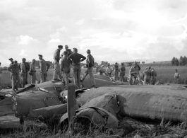 GIs inspect crashed B-24 in a grainfield in China during WWII, between 1943-1945. 