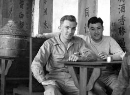 "China, Bert Krawczyk and George Clements sitting at a restaurant table with an unidentified Chinese boy." During WWII.