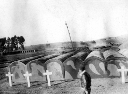 GI walks in front of vaults at an American military graveyard at Kunming, during WWII.