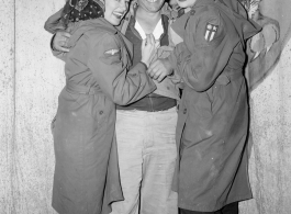 Celebrities visit and perform at Yangkai, Yunnan province, during WWII: Happy GI poses with two starlets 0n the stage at Last Resort.