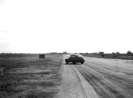 Car on a runway, probably in India or Ceylon, during WWII.