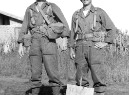 Two GIs in combat gear, either in in China, or possibly at Camp Swift, Texas during training. During WWII.  Curiously, the sign in the ground in front of them says "Dew Drop In."